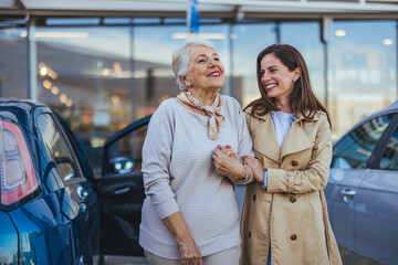 Cheerful Senior Woman and Daughter Smiling Outside a Car Dealership
