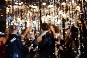 a group of people enjoying the holiday, dancing and laughing against the backdrop of sparkling...
