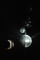 Obraz premium three disco balls suspended against a black space, reflecting the light and creating a retro party atmosphere. party poster in the style of the 80s or for visual advertising of events with an atmosphe