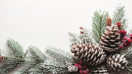 Festive christmas foliage background with pine cones and frosted red berries on evergreen Christmas tree spruce fir branches, winter holiday decor frame on white backdrop, natural nature seasonal