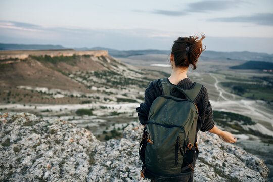 adventure awaits woman with backpack gazing over valley from mountain summit