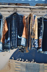 Close-up of traditional Moroccan garments with intricate patterns and bold colors hanging on...