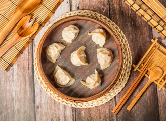 Steamed Shrimp Dumplings with chopsticks and spoon served in bamboo steamer isolated on wooden table top view of taiwan food