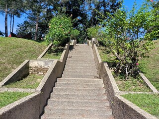 A tranquil scene with a staircase leading up a hill,surrounded by nature