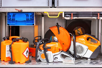 Chainsaws, fuel containers, safety gear neatly organized on metal shelf ready for professional outdoor work equipment concept