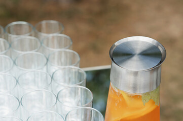 Refreshing beverage and clear glasses set on a table at an outdoor gathering