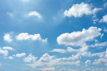 Fluffy cumulus clouds drift across a vibrant blue sky