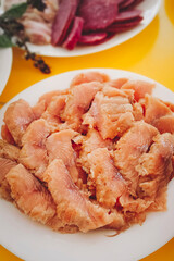 Pieces of lightly salted red fish lie on a plate. Close-up, vertical photo.