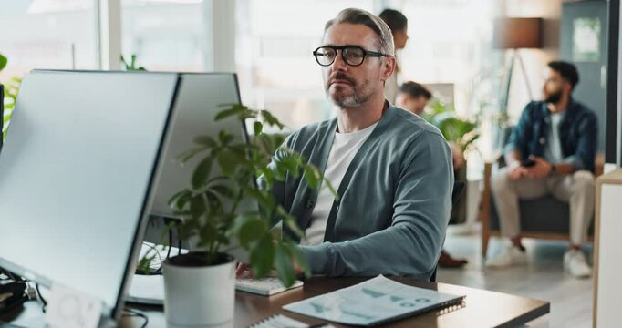 Computer, glasses and web development with man software engineer in office for coding or programming. Desktop, reading and typing with mature employee in workplace for design or online research