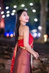 Portrait Beautiful asian woman in Thai traditional Thai dress costume in front of Pagoda temple at the ancient city Thailand,Loy Krathong Festival,At the Thai temple fair at night