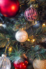 Christmas tree with red, gold and silver toys. Festively decorated Christmas tree with garlands. Symbol of the new year in trend colors