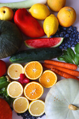 Various seasonal fruits and vegetables on white background. Summer and fall produce. Top view.