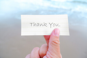 Thank You message in a hand at the beach