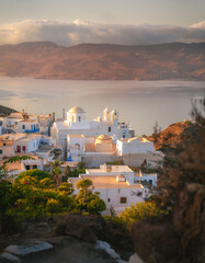 Stunning view from Milos Island's peak, Greece: a white church overlooks the vast Aegean Sea,...