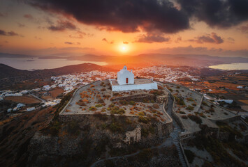Stunning view from Milos Island's peak, Greece: a white church overlooks the vast Aegean Sea,...