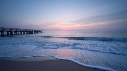 A pier on the beach at sunset