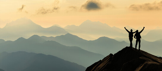 Silhouette of  people standing on top of a mountain 
