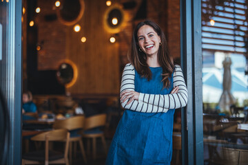 Smiling Woman Standing in a Cozy Coffee Shop Entrance