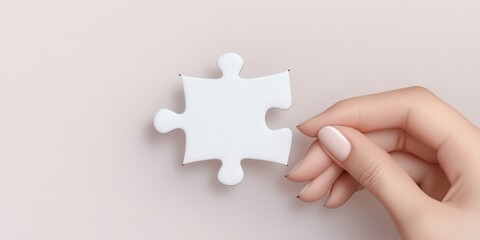 A hand gently holds a single white puzzle piece against a soft, light background, symbolizing completeness and the search for answers.