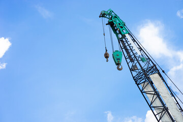 Naklejka premium Hoist/crane with blue sky and cloud in background