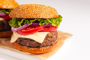 Hamburger made of beef, onion, tomato, lettuce, cheese and spices. Fresh burger closeup. Cheeseburger.