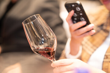 holding glass of red wine