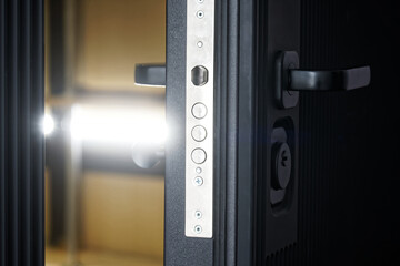 Door lock on a slightly open entrance metal armored door with thermal insulation and sound...