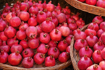 Many ripe pomegranates lie in a wicker baskets.