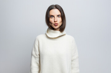 Fototapeta premium Beautiful funny woman doing some grimace looking at the camera. On white background.