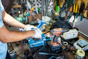 Mechanical man hand working fix electric drill motor roter