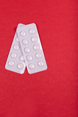 White Pharmaceutical Pills in Blister Packs Arranged on Vibrant Red Background - Medication, Healthcare, and Medical Treatment Concept