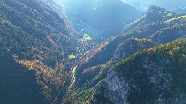 Aerial view of Logar Valley, Slovenia. Sunlight filters into a valley surrounded by a mountain range. Kamnik-Savinja Alps