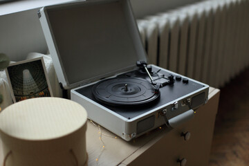 a vintage vinyl record player elegantly positioned on a rustic wooden table. a sense of nostalgia and appreciation for the analog sound, inviting viewers to immerse themselves in the world of classic