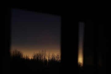 Sunset clouds mirrored in the window. Nature sunset sky backdrop. Blurry abstract sunrise background