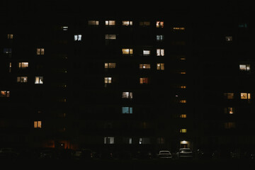 residential apartment building at night with different lights from windows and balconies 