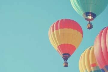 Fototapeta premium A set of brightly colored hot air balloons rising into a clear sky. 