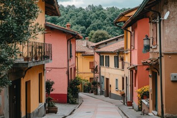 Fototapeta premium A street in a small Italian village lined with brightly painted houses in various shades of yellow, pink, and orange.