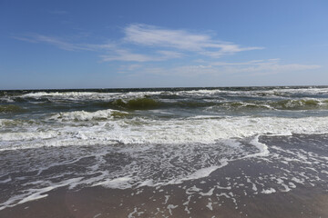 Sunny Ocean Waves on Sandy Shoreline with Blue Sky