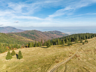 Naklejka premium Beautiful sunny autumn in the Silesian Beskid.Aerial drone view of beskid mountains in autumn.Colorful autumn trees and forest in the mountains. Glinne, Radziechowska, Barania in the Polish Beskids.