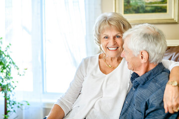 elderly 80s couple embracing each other at home