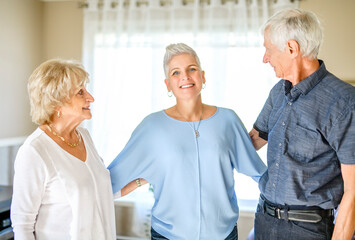 Fototapeta premium Happy daughter embracing her two elderly parents at living room. Love and care.