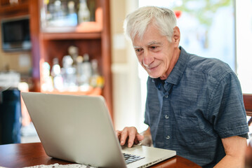 Fototapeta premium men senior in front of laptop at home