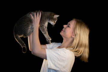 Smiling Woman Holding Cat in Loving Interaction on Black Background