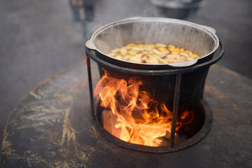 The Glow of Embers and Flames in a Steel Cooking Pot Outdoors Under the Starry Sky