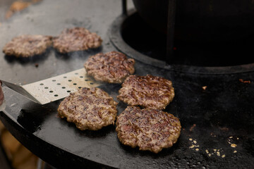 Sizzling, Mouthwatering Burgers Cooking Perfectly on a Griddle at a Summer BBQ Event