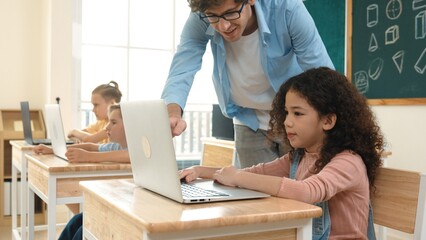 Obraz premium American girl learning about coding engineering prompt while diverse students sitting at STEM technology class. Multicultural children working on laptop to generated AI by using software. Pedagogy.