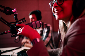 Female podcaster making podcast with young man from her studio.