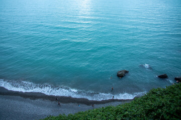 A person is standing on a scenic beach beside a beautiful body of water