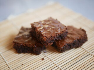 Moist and rich brownies or chocolate cake stacked on a serving plate.