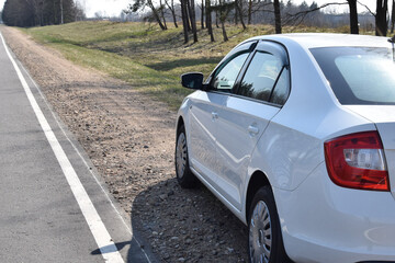 Traveling by car. A white car stopped for a rest on the side of the road